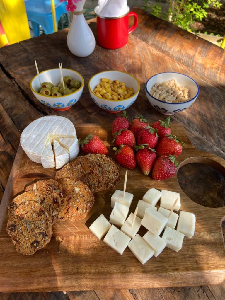 Desayuno con quesos, frutillas y pan casero en La Taza